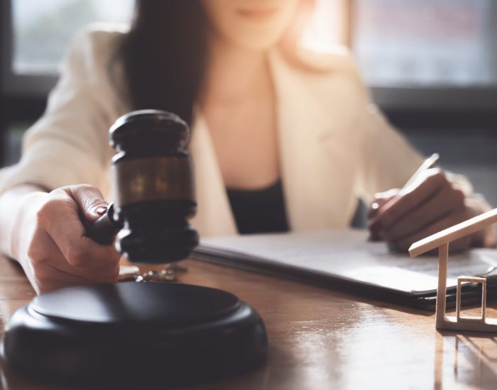 Close up Hand of Business woman or lawyers checking contract papers with on wooden desk in office. Law, legal services, advice, Justice concept.